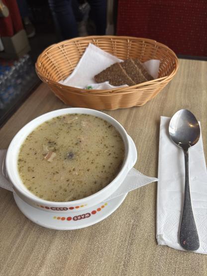 Bowl of soup and a basket of bread.
