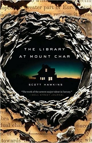 The cover for The Library at Mount Char by Scott Hawkins.

The cover shows a stack of papers with a hole burned right through them. In the hole, the silhouette of a lit-up house is visible against the background of an eerie glow in the sky