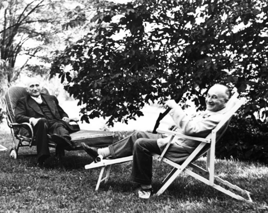 Foto blanco y negro de Jean Monnet y Robert Schumann en modo relax en un jardin. 