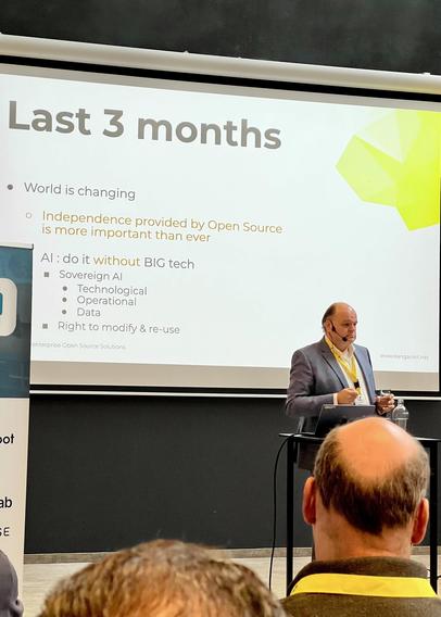 Photo of Peter Dens giving his keynote before a screen