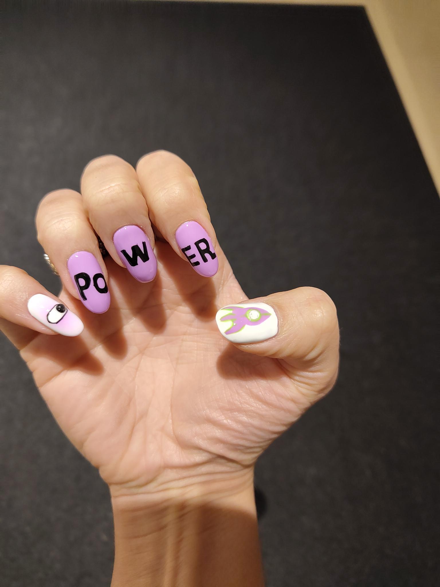 Naildesign in violet congress design saying "POWER" + Rocket on thumb